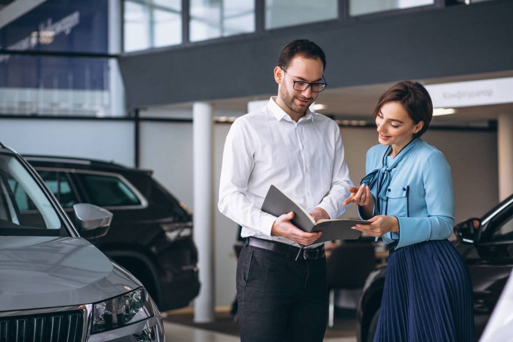 Man showing woman car paperwork